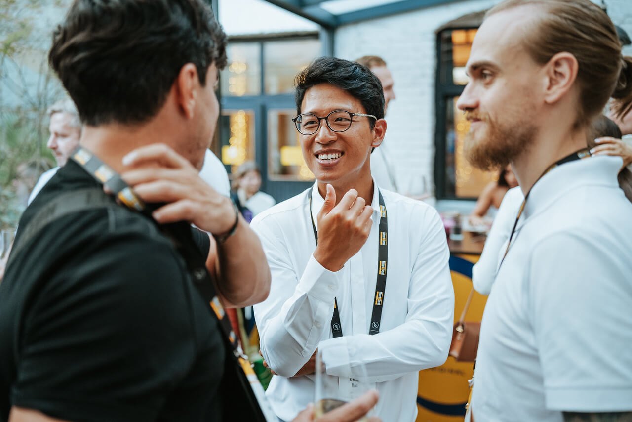 Tři účastníci konference při networkingu