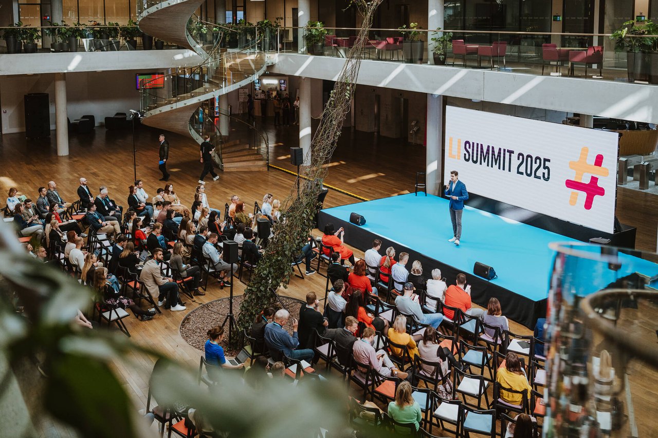 Pohled shora na pódium a publikum LI SUMMITu v atriu